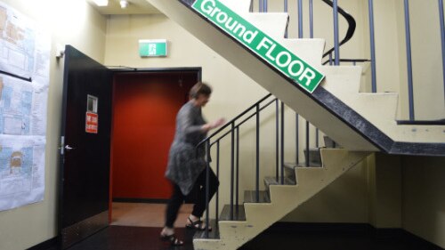 A staff member walks upstairs from the ground floor studio.