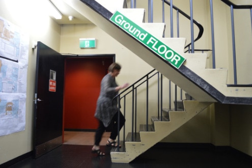 A staff member walks upstairs from the ground floor studio.