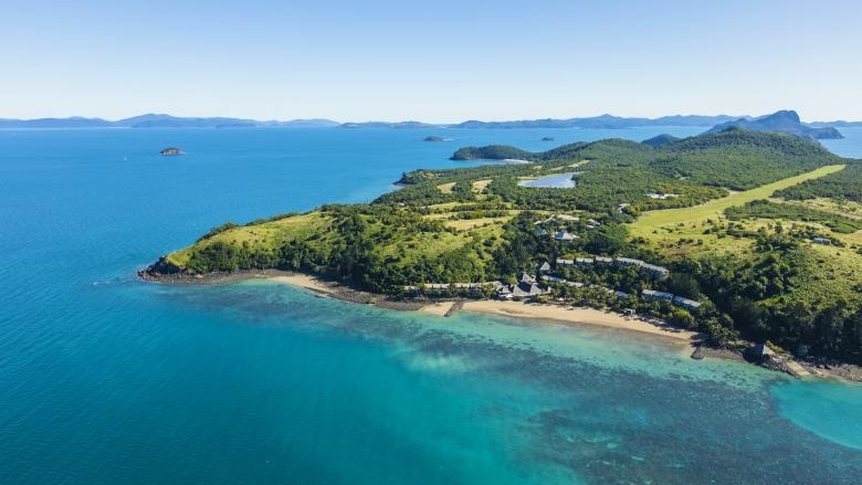 Arial shot of a hilly tropical island surrounded by water 