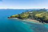 Arial shot of a hilly tropical island surrounded by water 