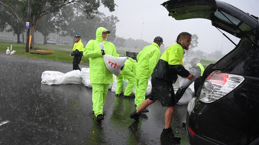 Penrith City Council workers load sandbags into a resident's car.