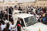 Pope Francis waves to believers from his vehicle in the Central African Republic.