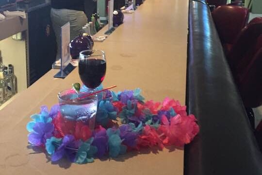 Two drinks surrounded by a wreath on the bar of the Kona Elks Lodge, Hawaii, set up as a tribute to two chopper crash victims