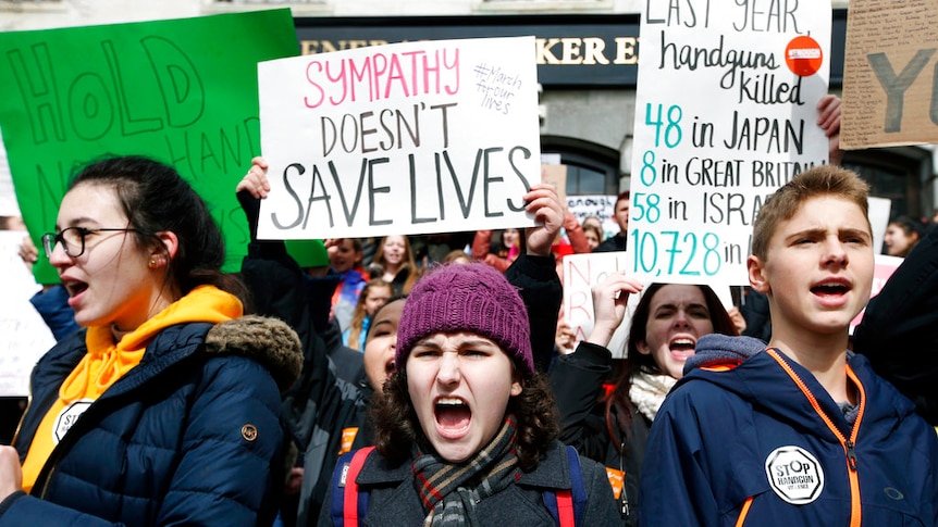 Students hold posters reading: 'Sympathy doesn't save lives'