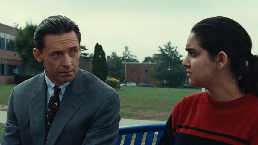 Hugh Jackman in a suit and Geraldine Viswanathan playing a student in a scene from Bad Education