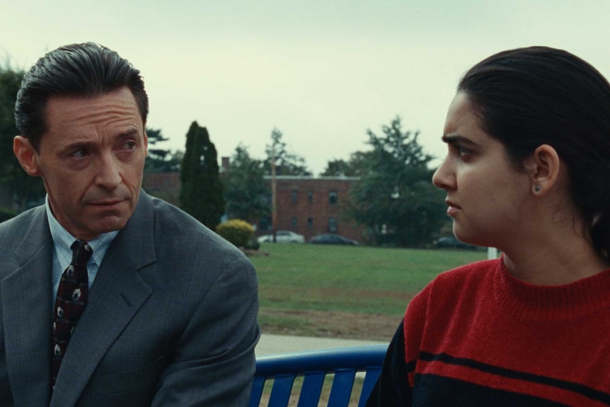 Hugh Jackman in a suit and Geraldine Viswanathan playing a student in a scene from Bad Education