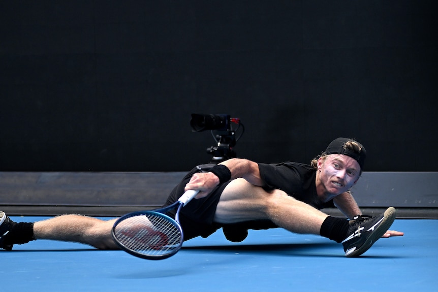 Tennis player Dane Sweeny is in the splits after playing a backhand at the Australian Open.