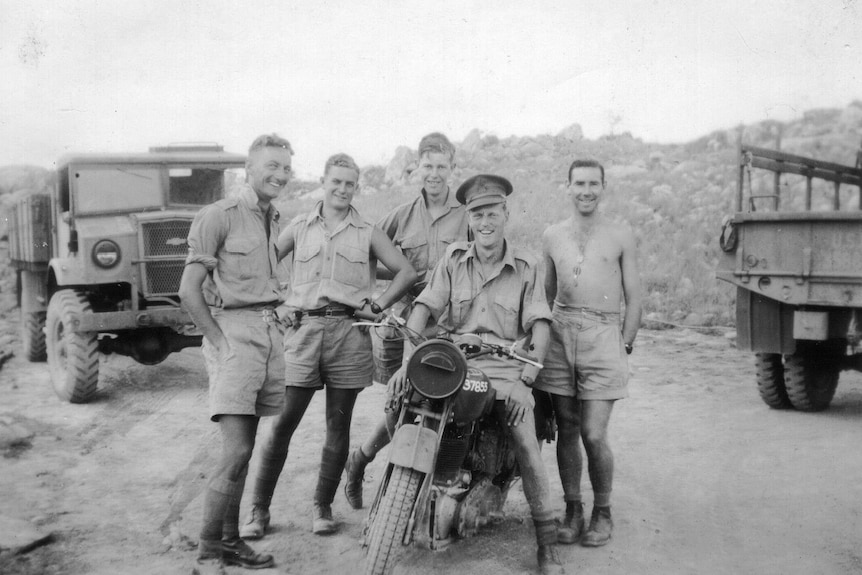 soldiers pose on a motorbike