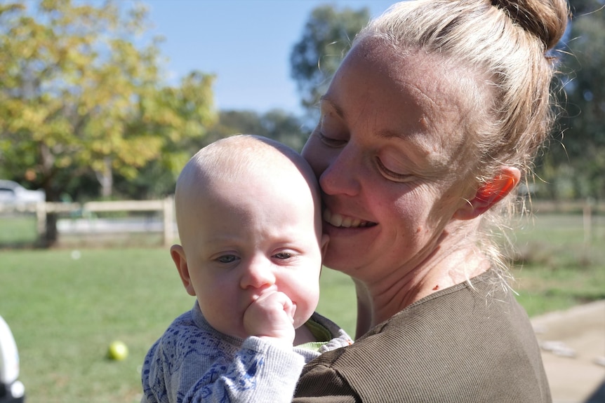 A mother snuggles into her baby