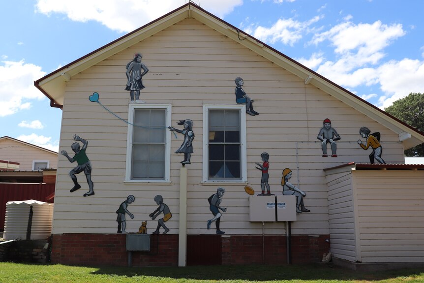 a mural on a building of school children playing