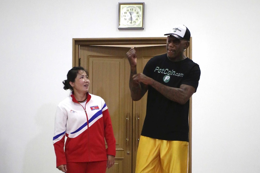 Judo gold medallist An Kum-ae stands next to Dennis Rodman.