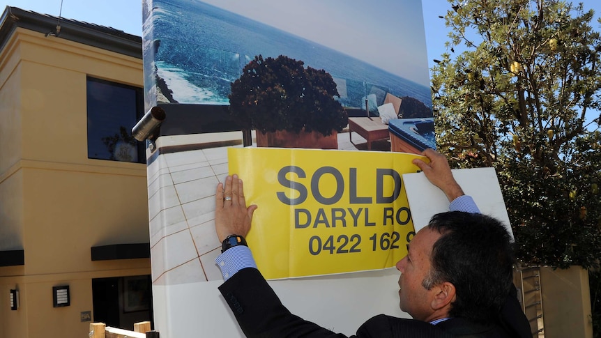 Real estate agent with sold sign