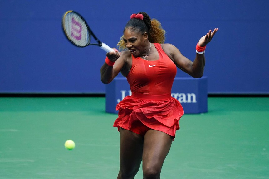 A tennis player grimaces as she hits a fierce forehand return at the US Open.