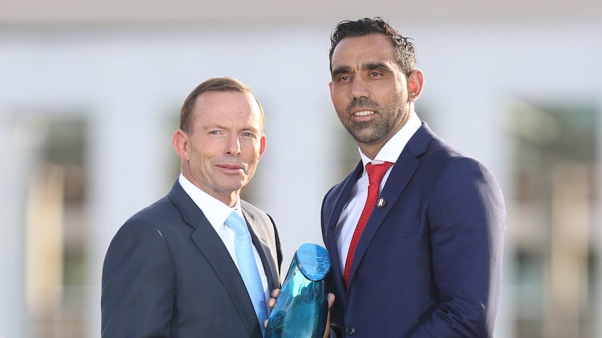Prime Minister Tony Abbott presents Adam Goodes with the Australian of the Year 2014 award