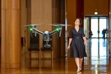 A drone films Annabel Crabb walking through Parliament House in Canberra during the making of The House TV series.