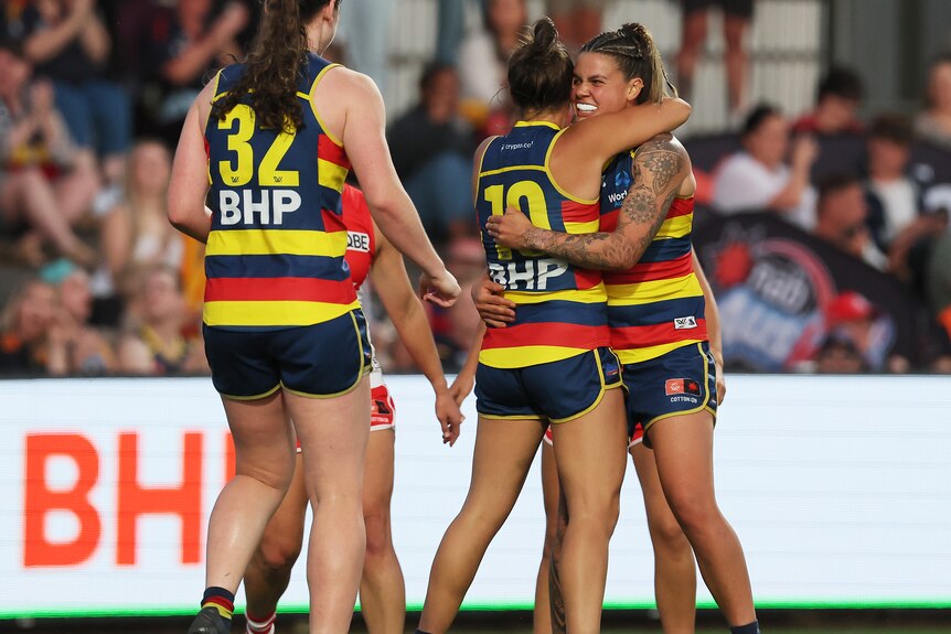 Anne Hatchard hugs Adelaide teammates in celebration