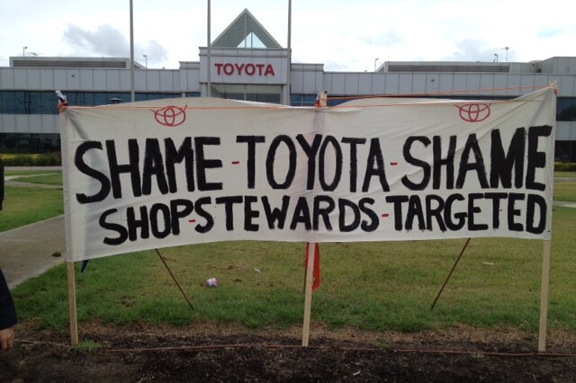 The sacked workers erected a banner over the Toyota sign.