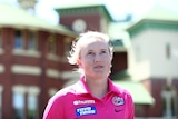 Sydney Sixers cricketer Alyssa Healy looks up as she stands with the SCG in the background.