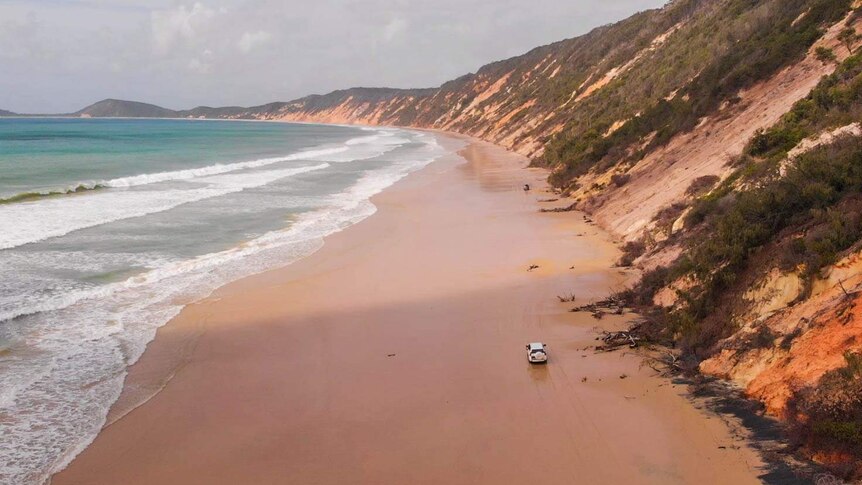 4WDs drive along Teewah beach in the Great Sandy National Park.