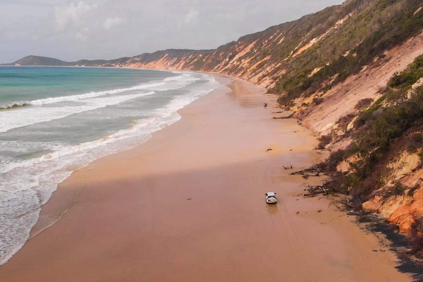 4WDs drive along Teewah beach in the Great Sandy National Park.