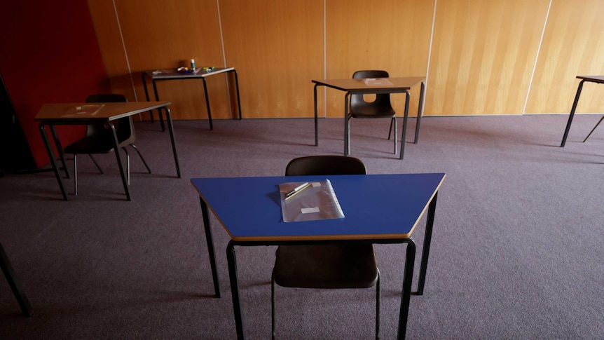 Empty desks are seen at a social distance in a classroom