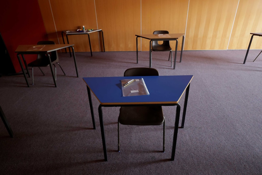 Empty desks are seen at a social distance in a classroom