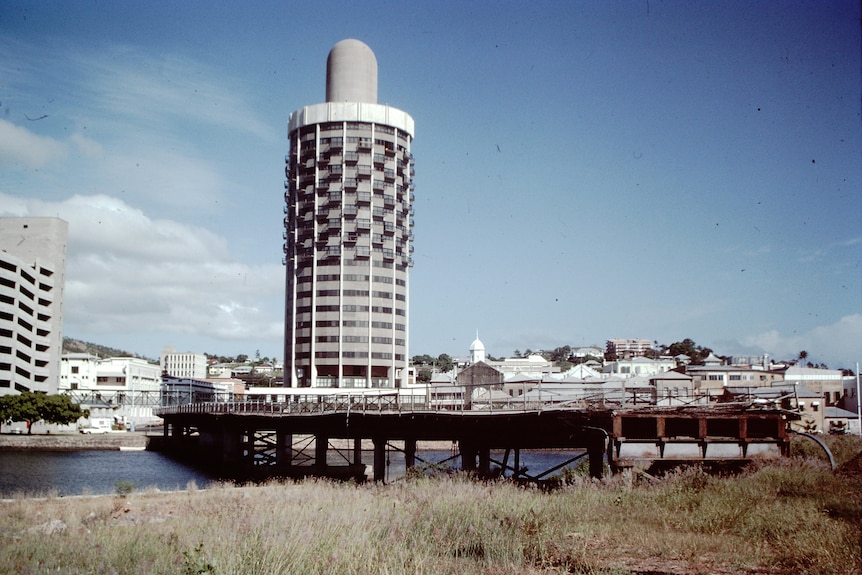 A color photograph of a regional city with one circular building preceding over all of the other properties.