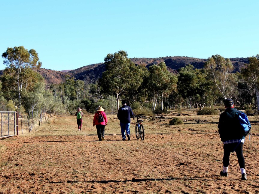 People walking on a dirt track.