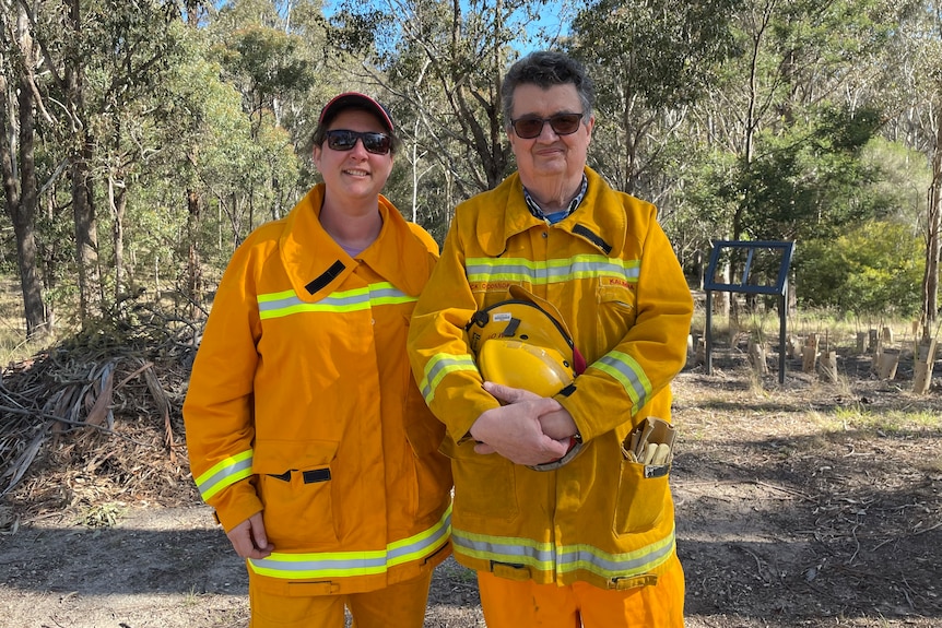 A woman and a man stand side by side, both wearing the orange CFA firefighting uniform.