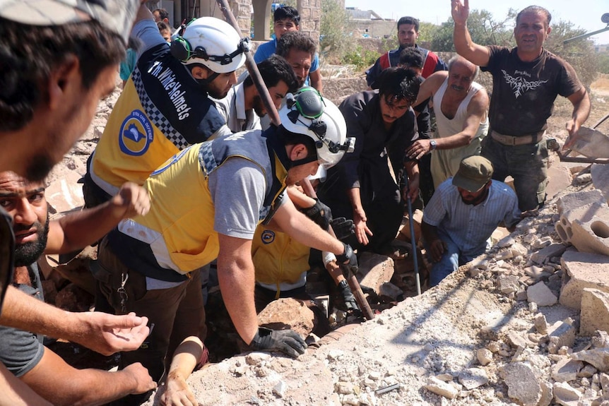 White Helmets defence workers search for victims under rubble of a destroyed building.