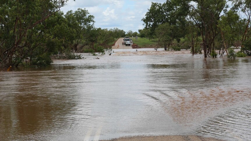 a flooded river with vehicles on the far side