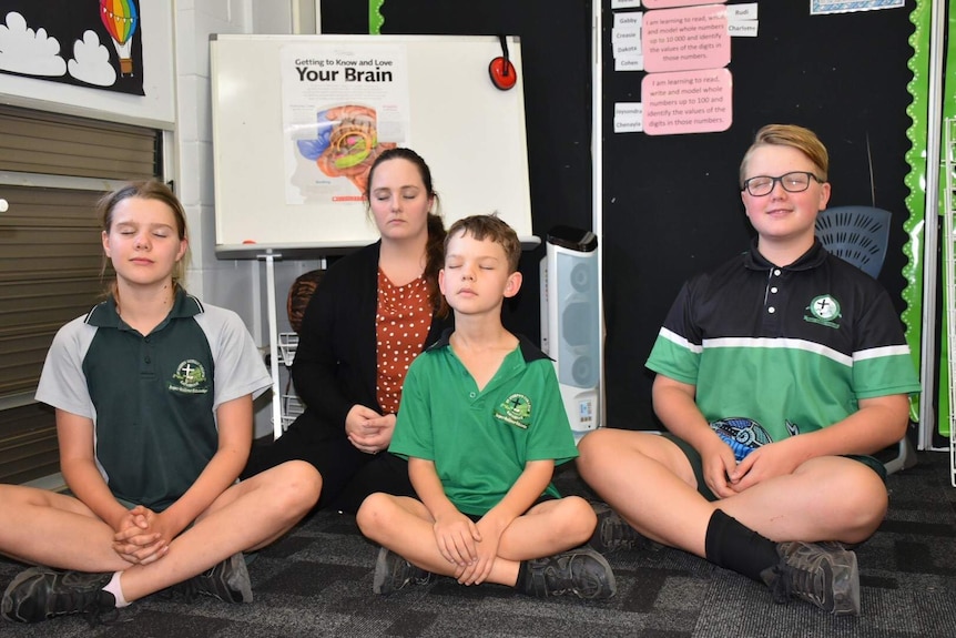 Children in class are meditating.