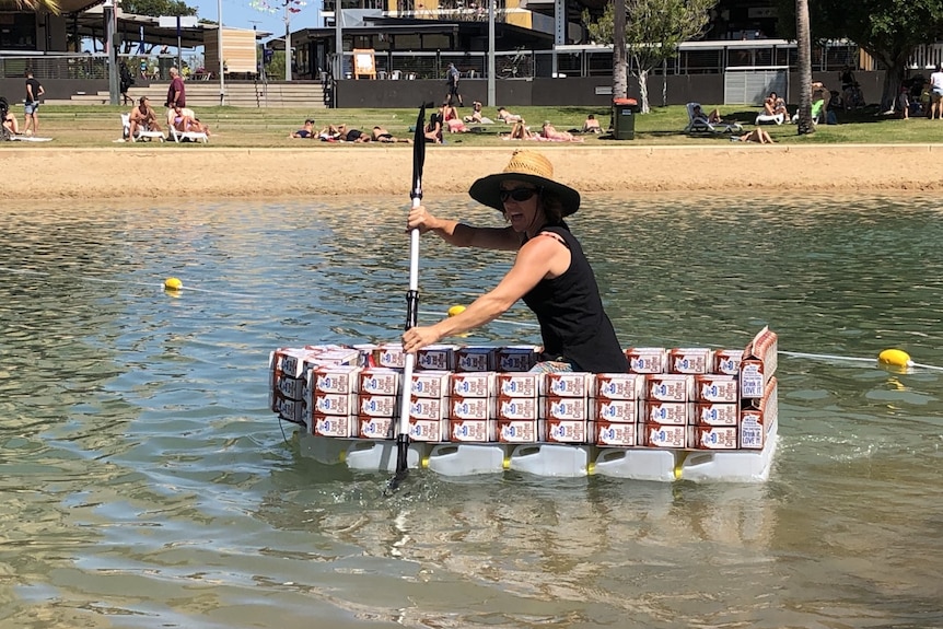 A woman kayaking on a boat made of milk cartons
