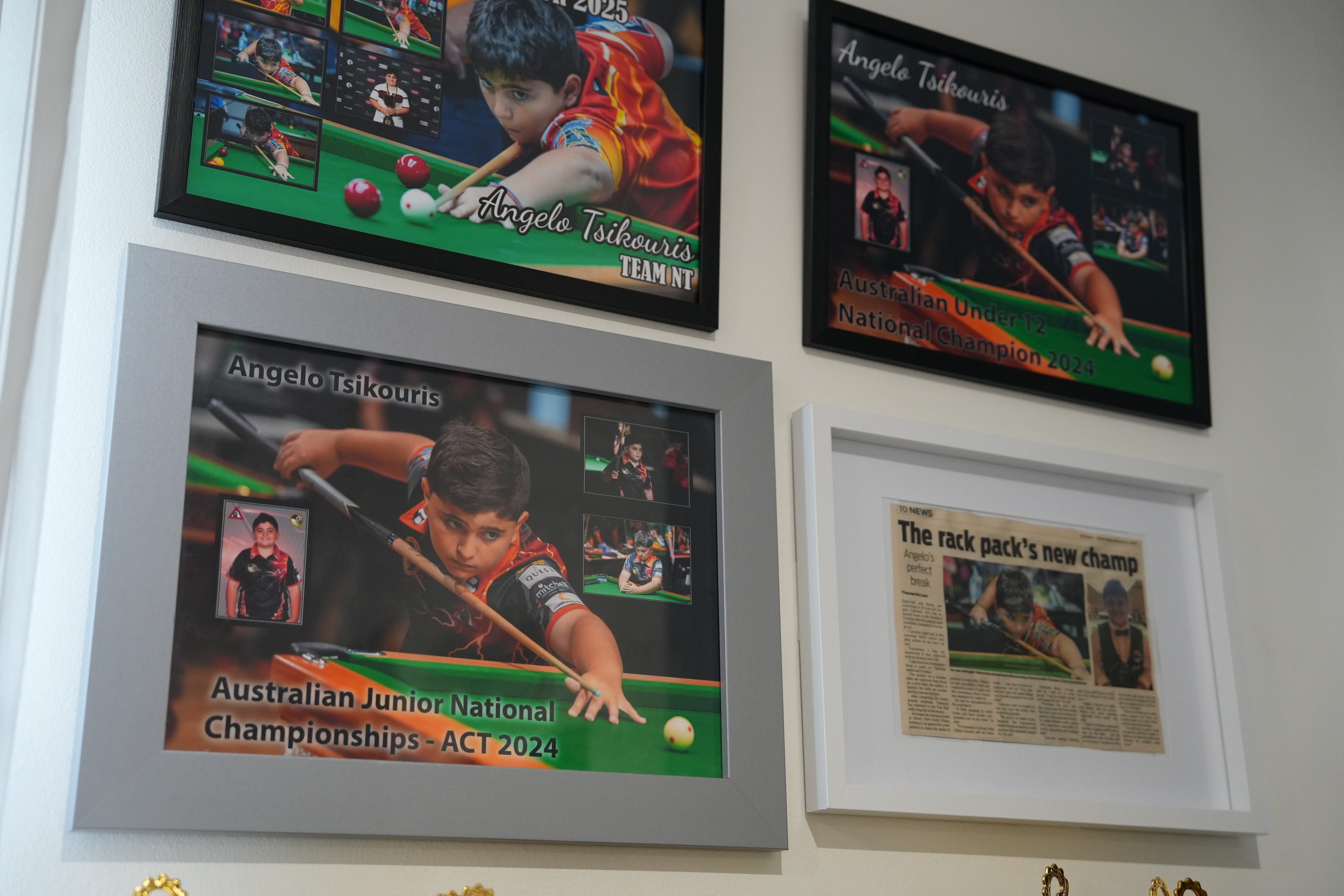 A wall of framed championship photos and newspaper clippings show some of the wins Angelo Tsikouris has secured.