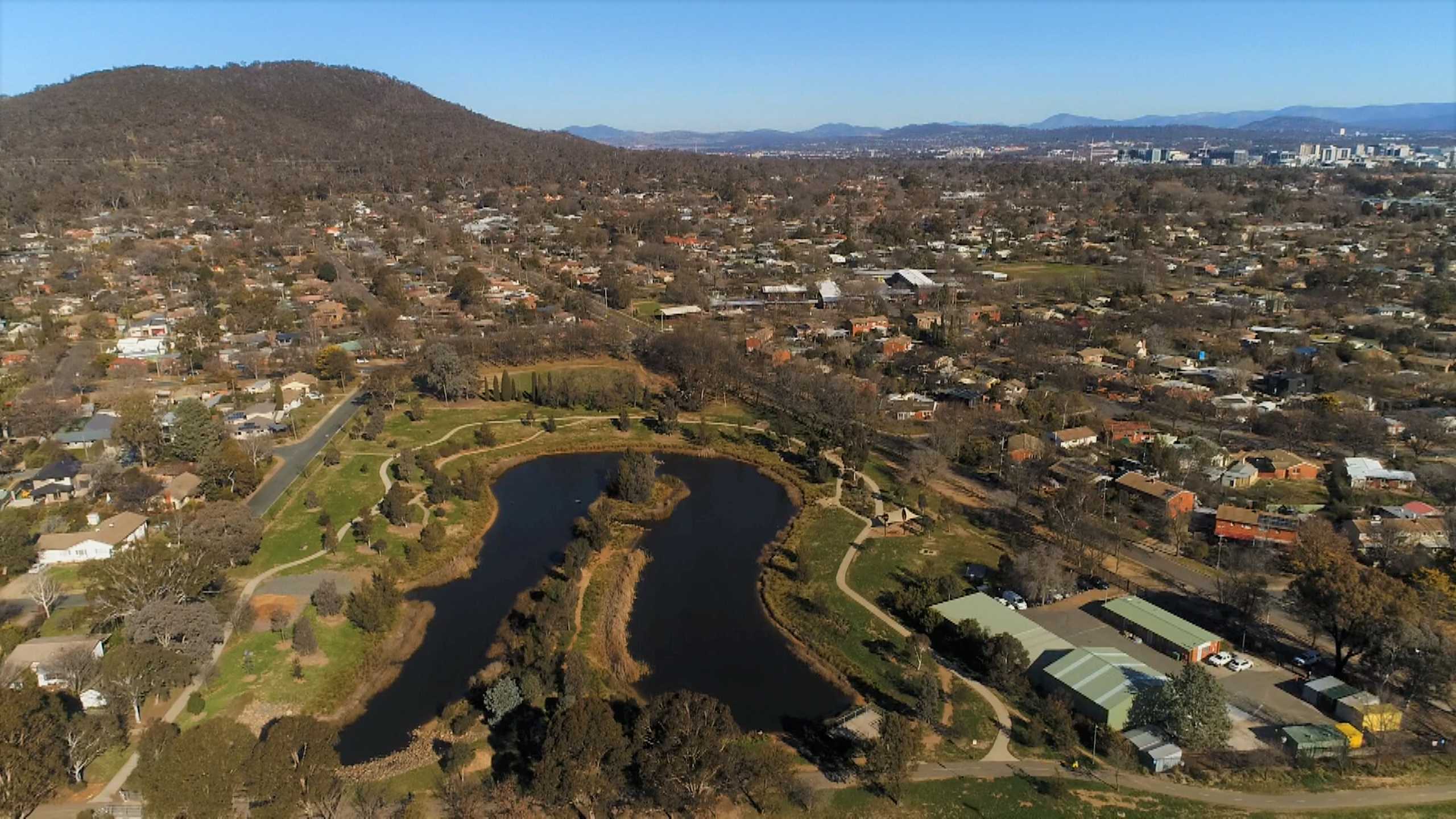 Una vista aérea de un estanque entre casas.