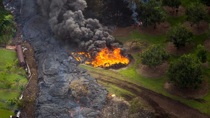 Lava from the Kilauea volcano sets fire to a stack of tyres near Pahoa in Hawaii.