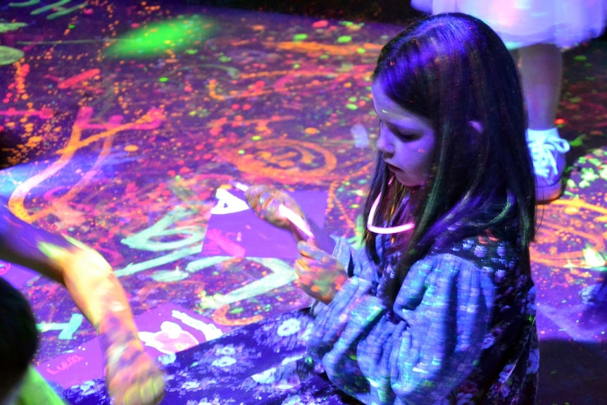 A girl plays with neon paints at Julian Scharf's party