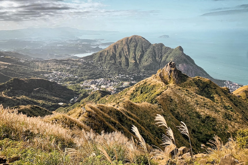 Grassy mountain ridge overlooking sea.