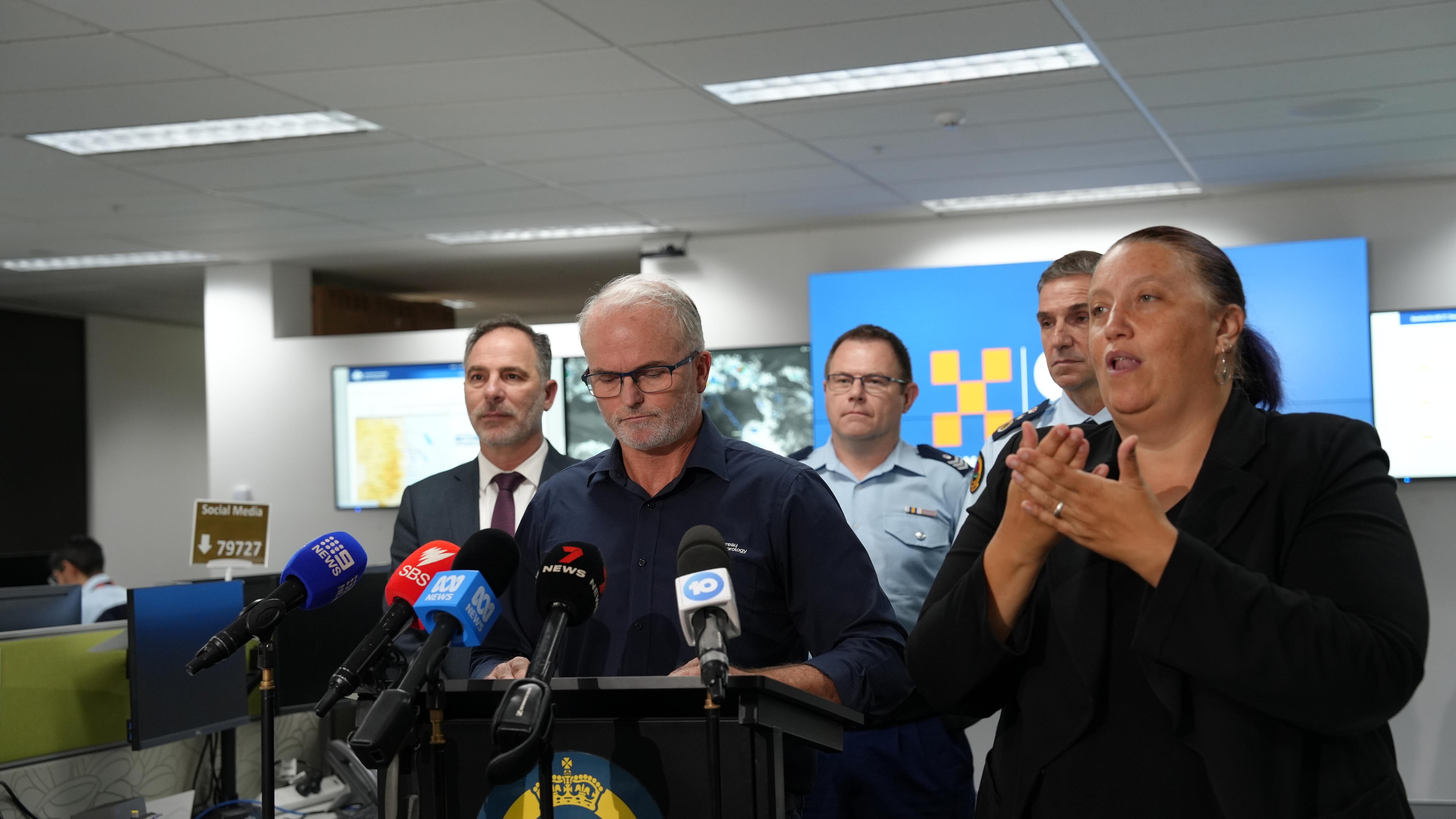 Steven Bernasconi speaks at press conference with SES figures behind him 