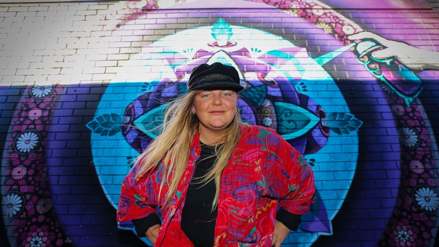 Young woman in front of mural