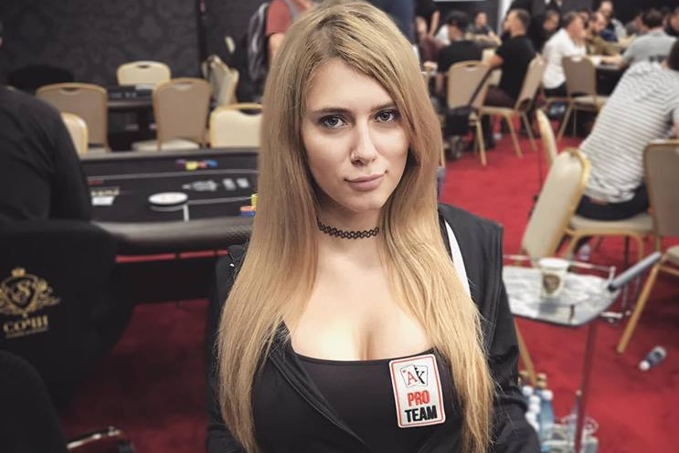 A woman sitting at a table with poker chips stacked in front of her.