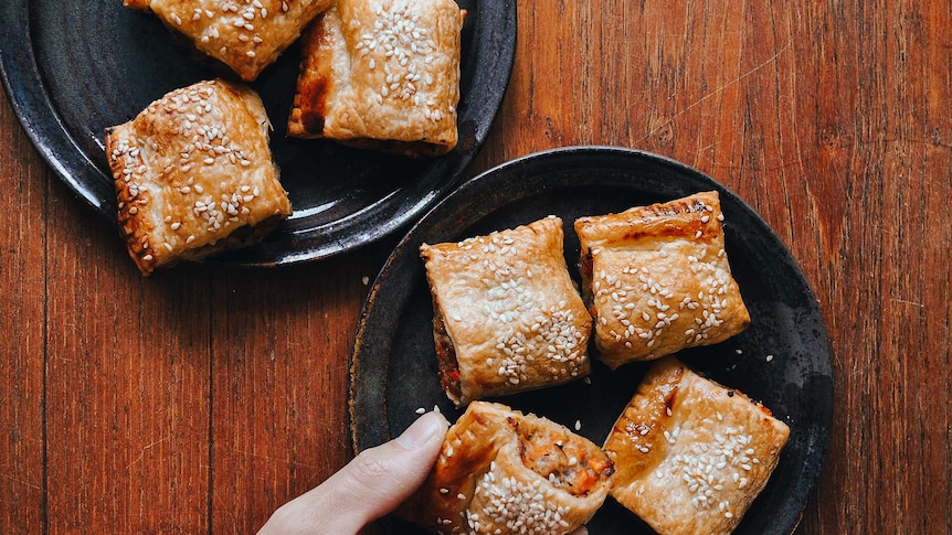 Two plates of bite-sized chicken and vegetable sausage rolls topped with sesame seeds, a fun family dinner recipe.