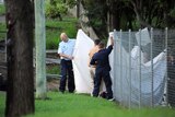 Detectives work at the scene of a crime where the body of an eight year old girl was found