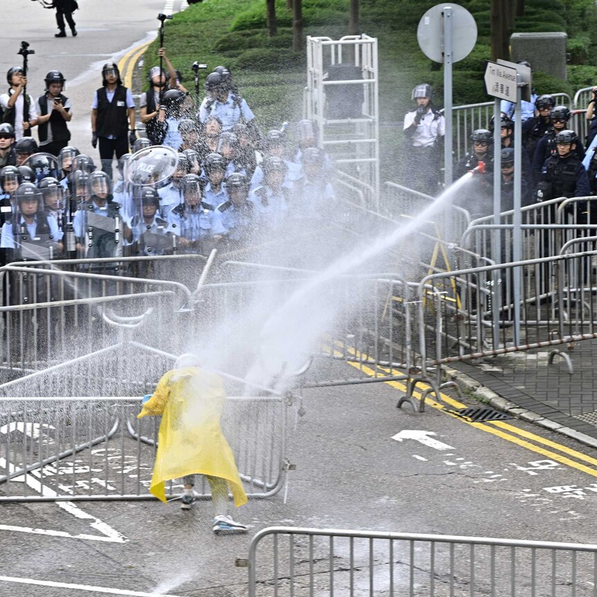 Police officers use water cannon on a lone protester near the government headquarters in Hong Kong.