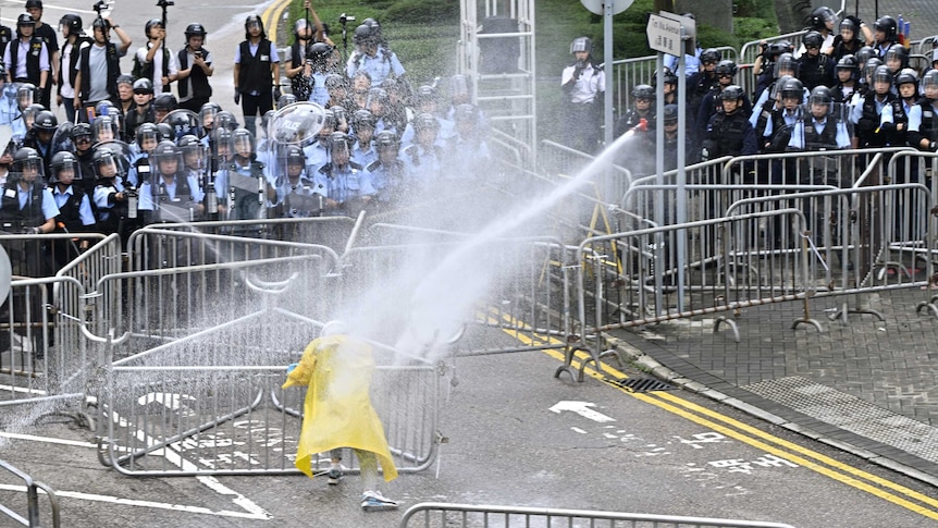 Police officers use water cannon on a lone protester near the government headquarters in Hong Kong.