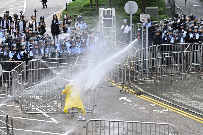 Police officers use water cannon on a lone protester near the government headquarters in Hong Kong.