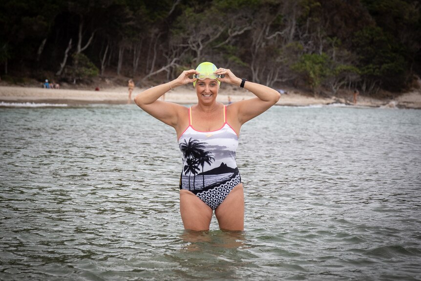 Caitlyn Feldmann in swimsuit and cap in the water, pictured in a story about budgeting for fitness