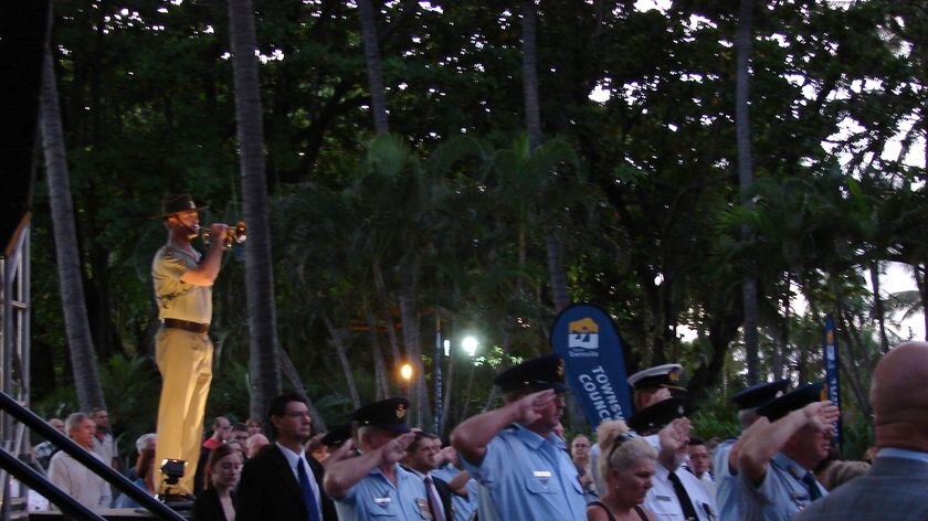 Crowds stand silent as soldier plays the Last Post at Anzac Day dawn service in Townsville.