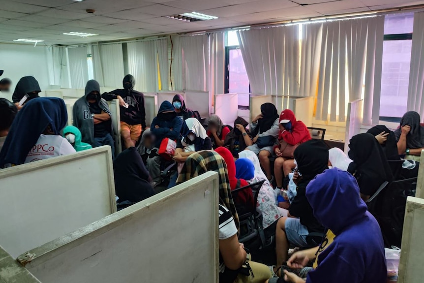 Unidentified workers crowded into an office in the Philippines.
