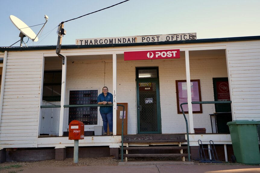 Woman standing outside while building saying Thargomindah Post Office